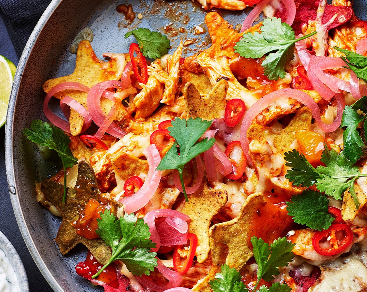 step 6 Remove the nachos from the oven and top with the remaining coriander, blobs of mango chutney (1 tbsp) and pickled red onions (1 tbsp). Serve with the homemade raita for dunking.