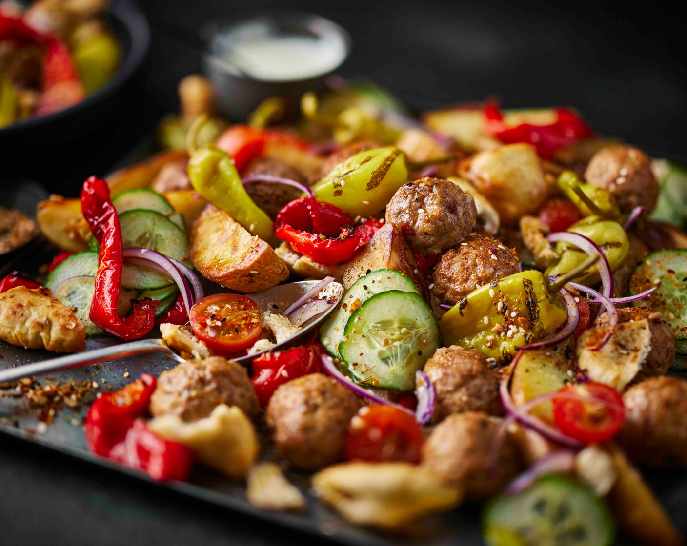 step 7 Once the meatballs are cooked, spoon over the tomato salad, drizzle with the garlic yogurt and finish with a few pepperoncini pickles (as needed).