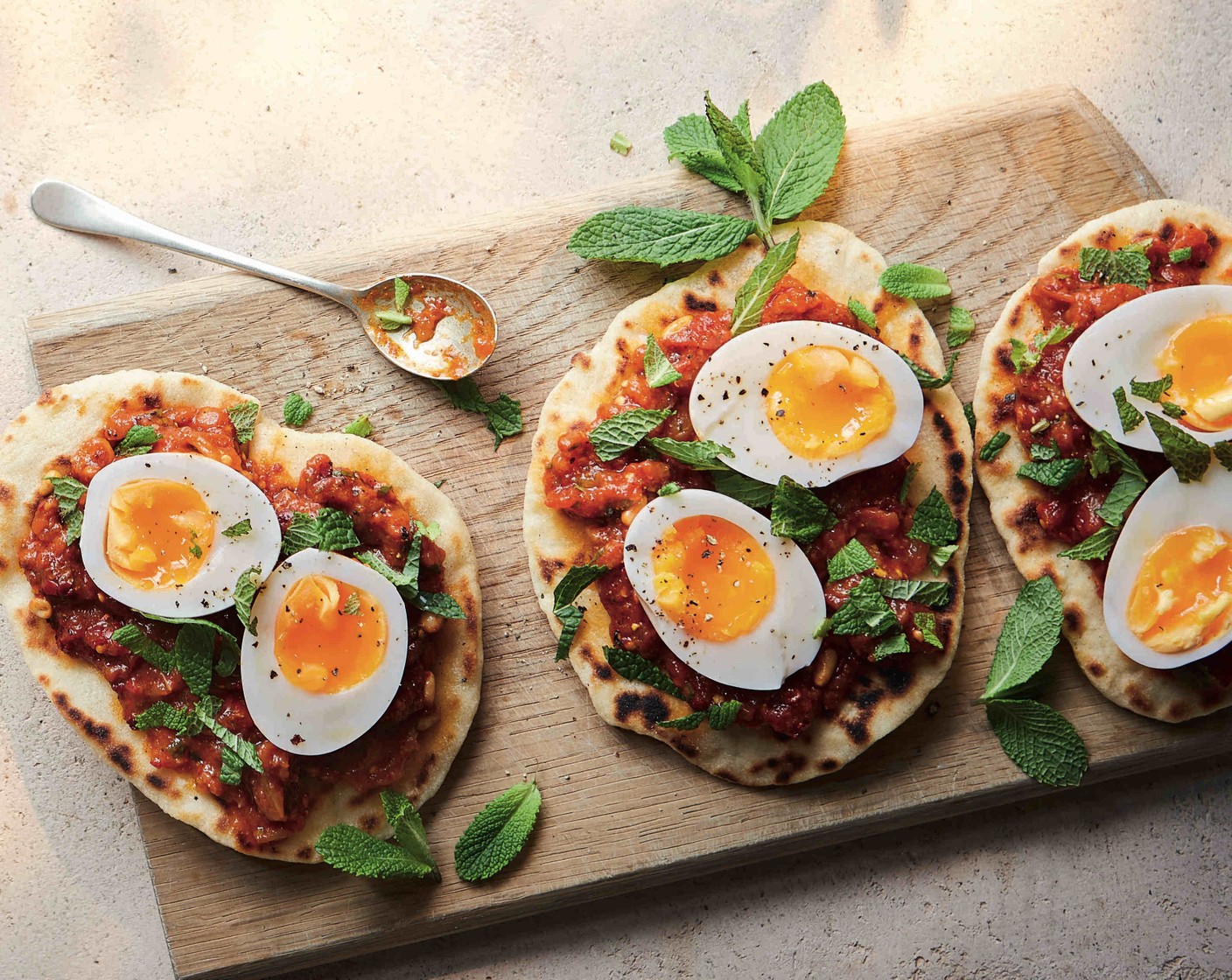 step 4 Spread the cooked flatbreads with the aubergine dip (1 pack) and top each with a halved soft-boiled egg. Finish with the fresh mint (1 handful).