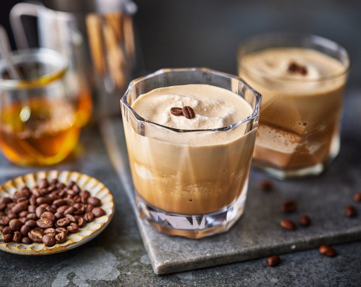 step 2 Transfer to a blender along with the coffee liqueur (50 ml), milk (100 ml), honey (1 tbsp) and vanilla paste (1/2 tsp). Whizz until smooth then pour into glasses and serve sprinkled with the coffee beans (as needed).