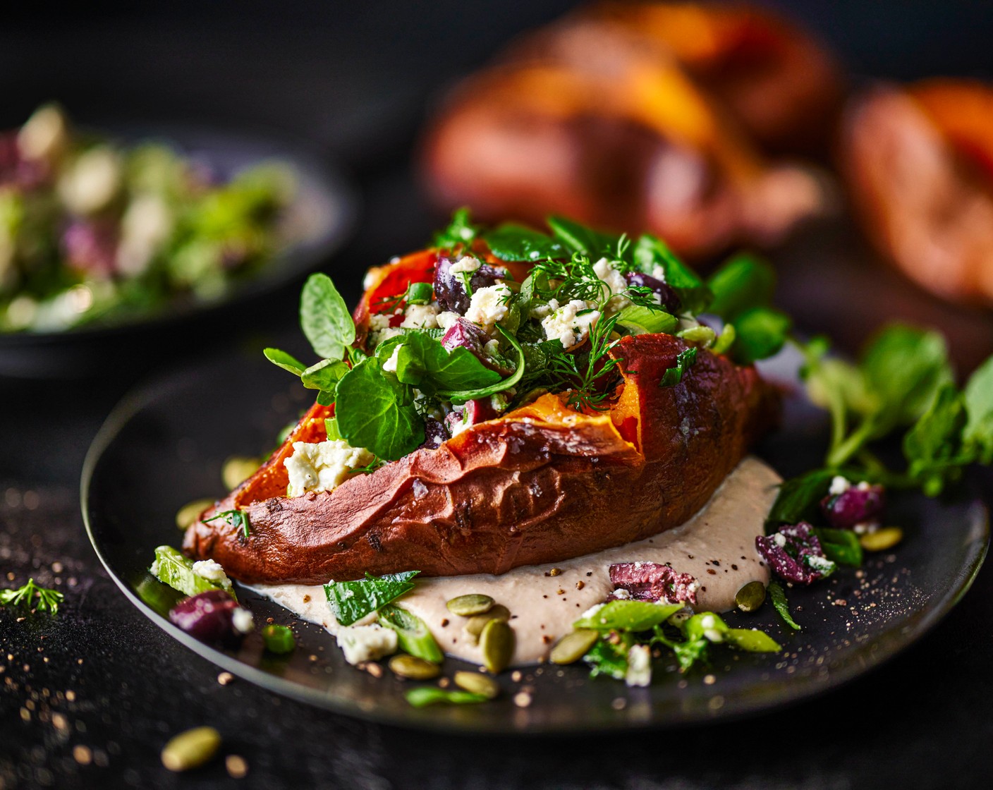 step 5 Add the watercress (100 g) and pumpkin seeds (15 g) to the feta salad and toss lightly. Spoon the tahini sauce onto plates, top with the sweet potatoes, then pile the feta and olive mixture over the top. Finish with a crack of black pepper before serving.