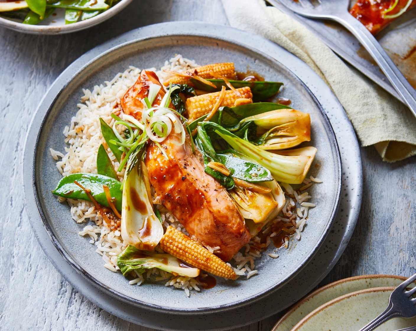 step 5 Divide the rice between 4 serving dishes. Add a salmon fillet and some of the stir-fried vegetables to each, and scatter with the spring onions (4).
