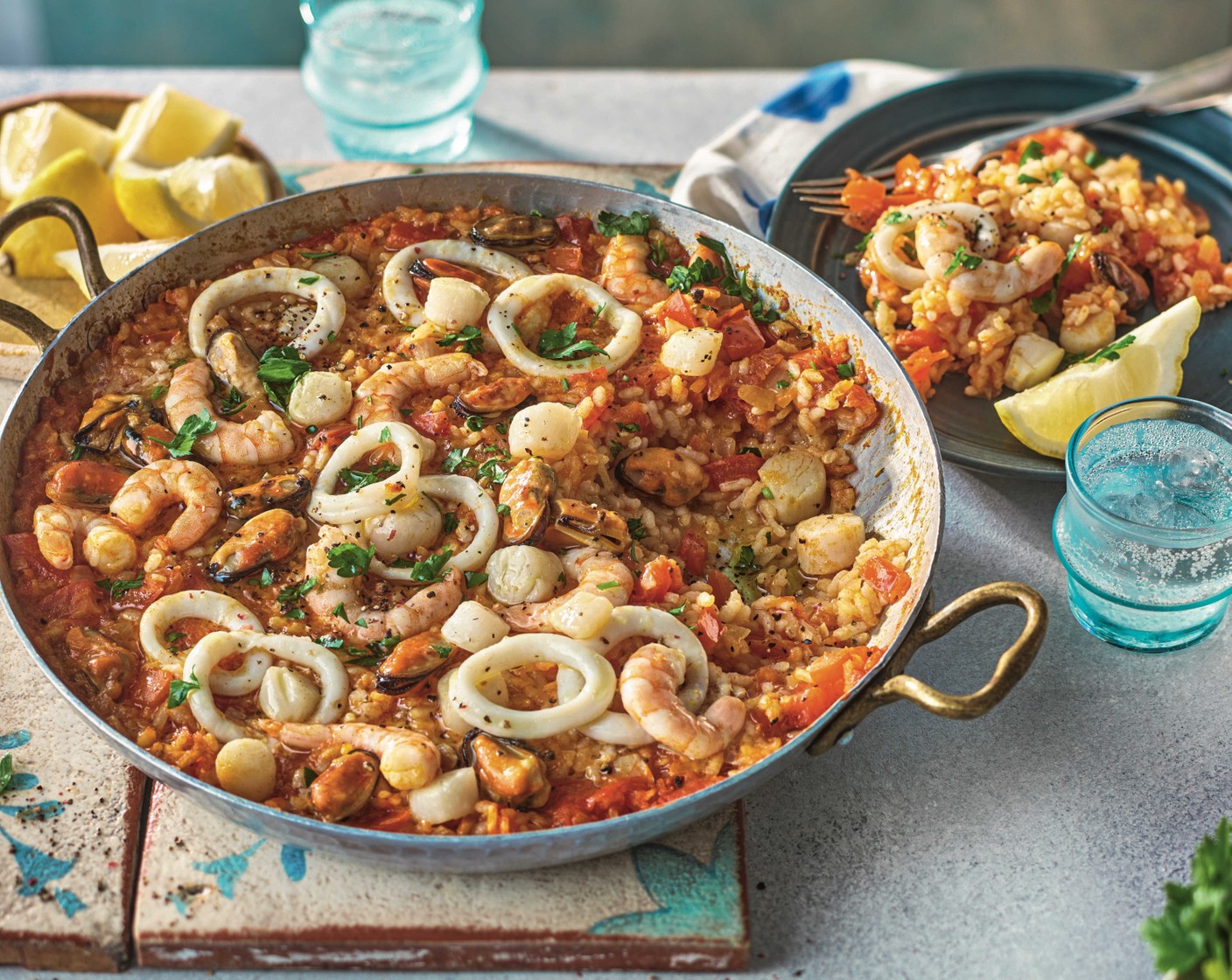 step 3 Stir in the seafood (1 pack) without disturbing the bottom of the pan. Cook for 7 minutes, until the prawns are pink and the rest of the seafood is cooked through. Serve the paella scattered with the chopped parsley (25 g), with the lemon wedges (1) alongside.