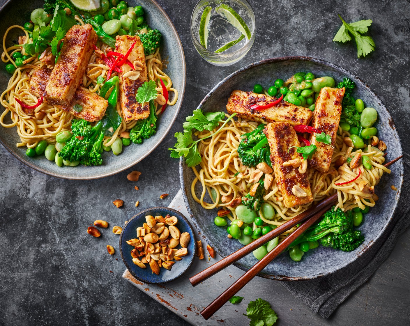 step 5 Serve the noodles and veg topped with the crispy tofu and sprinkled with fresh coriander (as needed) and M&S salted roasted peanuts (25 g), before finishing with lime wedges.