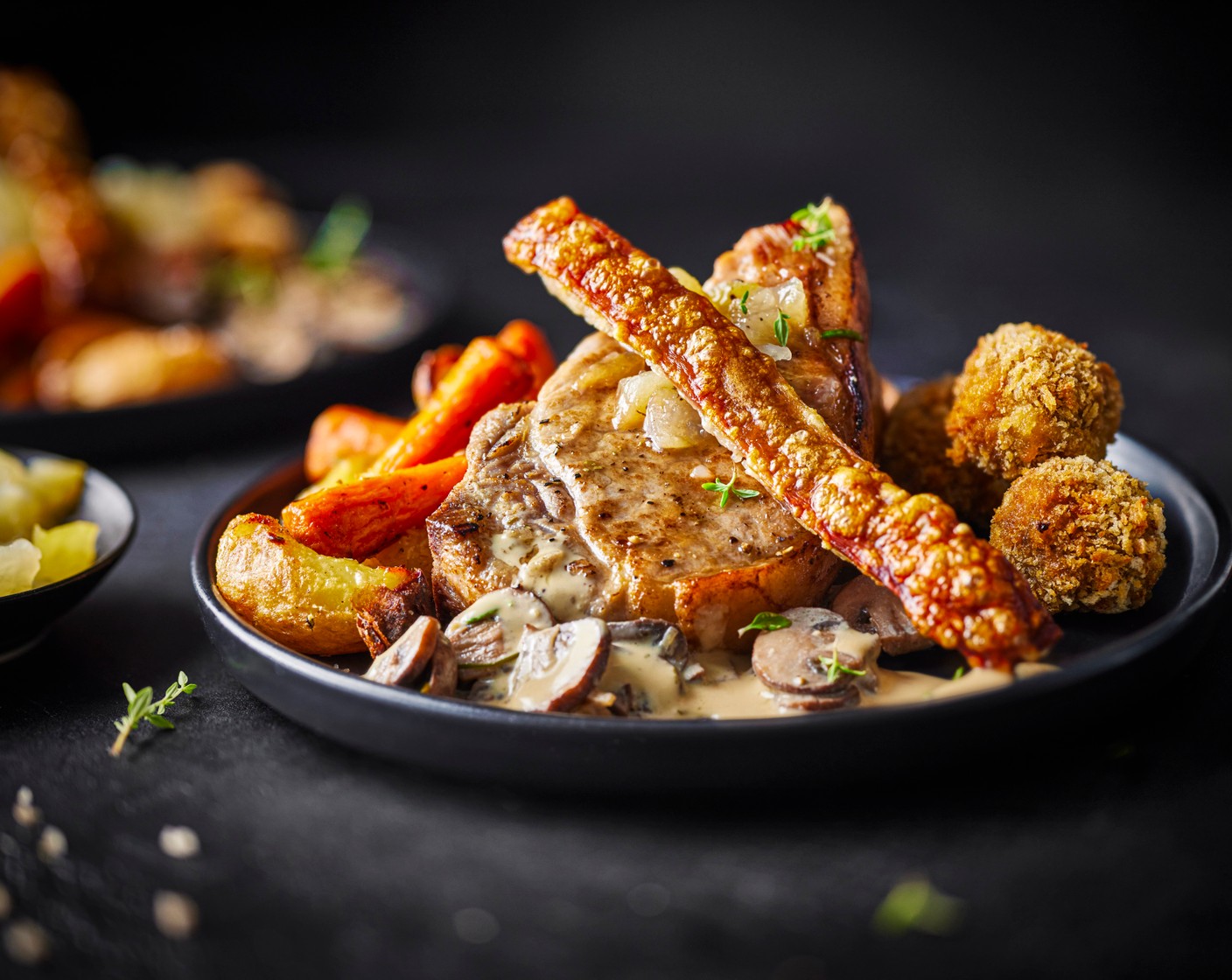 step 9 To serve, plate the pork chops with the spicy sausage bonbons, roasted baby potatoes and carrots. Top the pork chops with a dollop of apple sauce (3 tbsp) and the crackling straws. Spoon over the brandy and mushroom sauce.