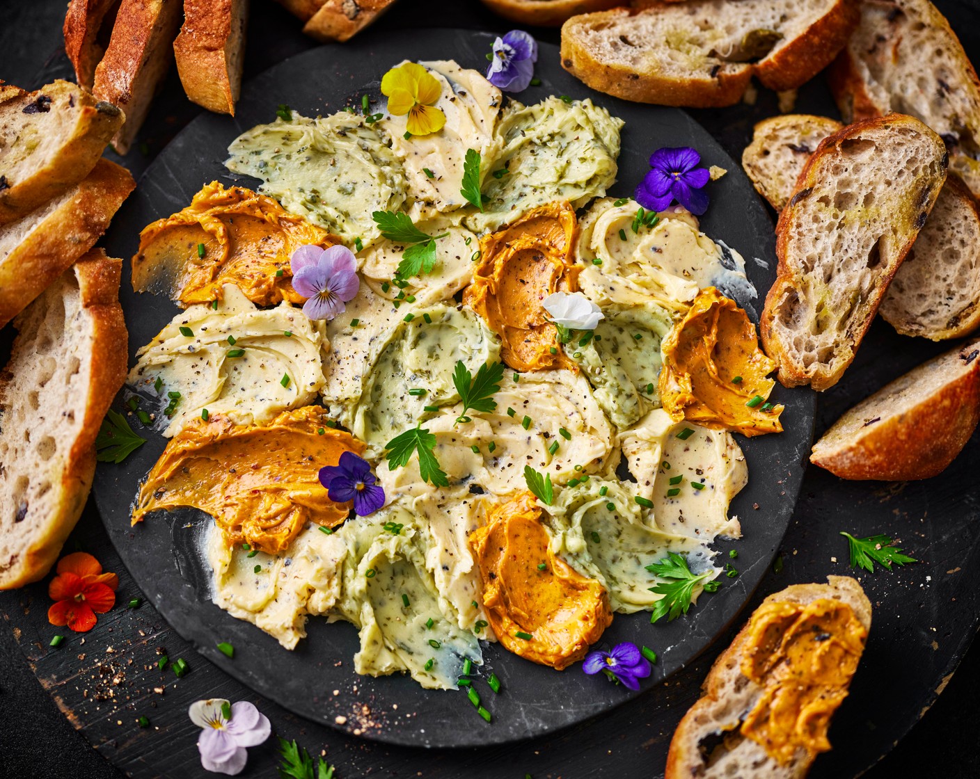 step 4 When you’re ready to serve, top the butter board with the parsley leaves (15 g), chopped chives (10 g) and edible flowers (10). Bring to the table with the toasted ciabatta, ready to dig in.