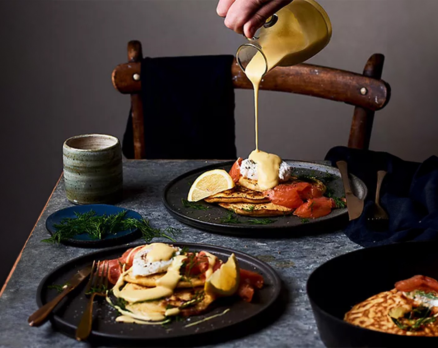 step 4 Stack a couple of pancakes per person, divide the smoked samon (100 g) between plates, draping over the stack. Place a poached egg on each stack and pour over the warmed hollandaise sauce (1 pouch). Garnish with a slice of lemon (1) and a small sprig of dill (to taste), if you wish.