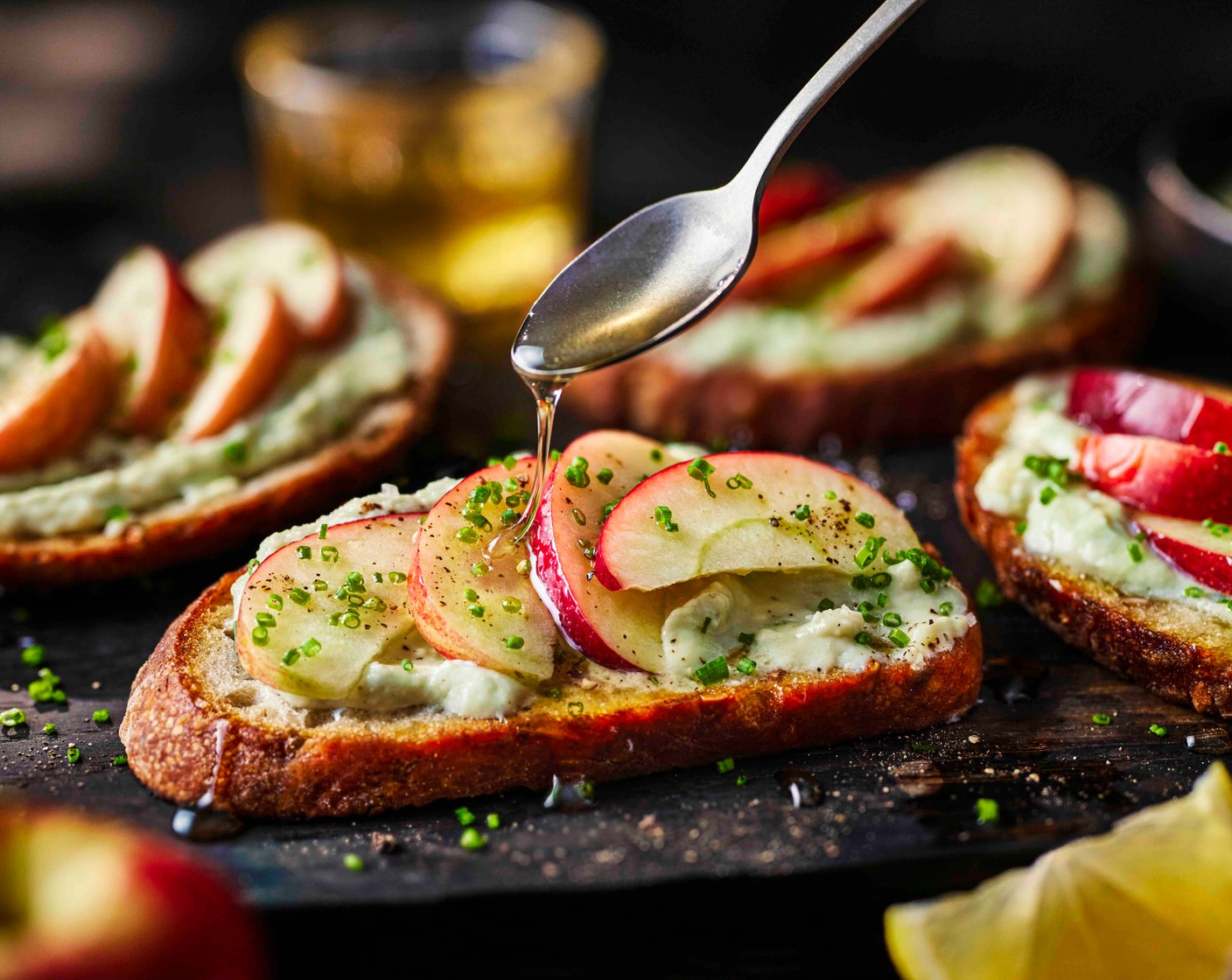 step 3 Spread the toasted sourdough with the whipped blue cheese, top with the sliced apples and a drizzle of honey (4 tsp). Finish with the chopped chives (5 g).