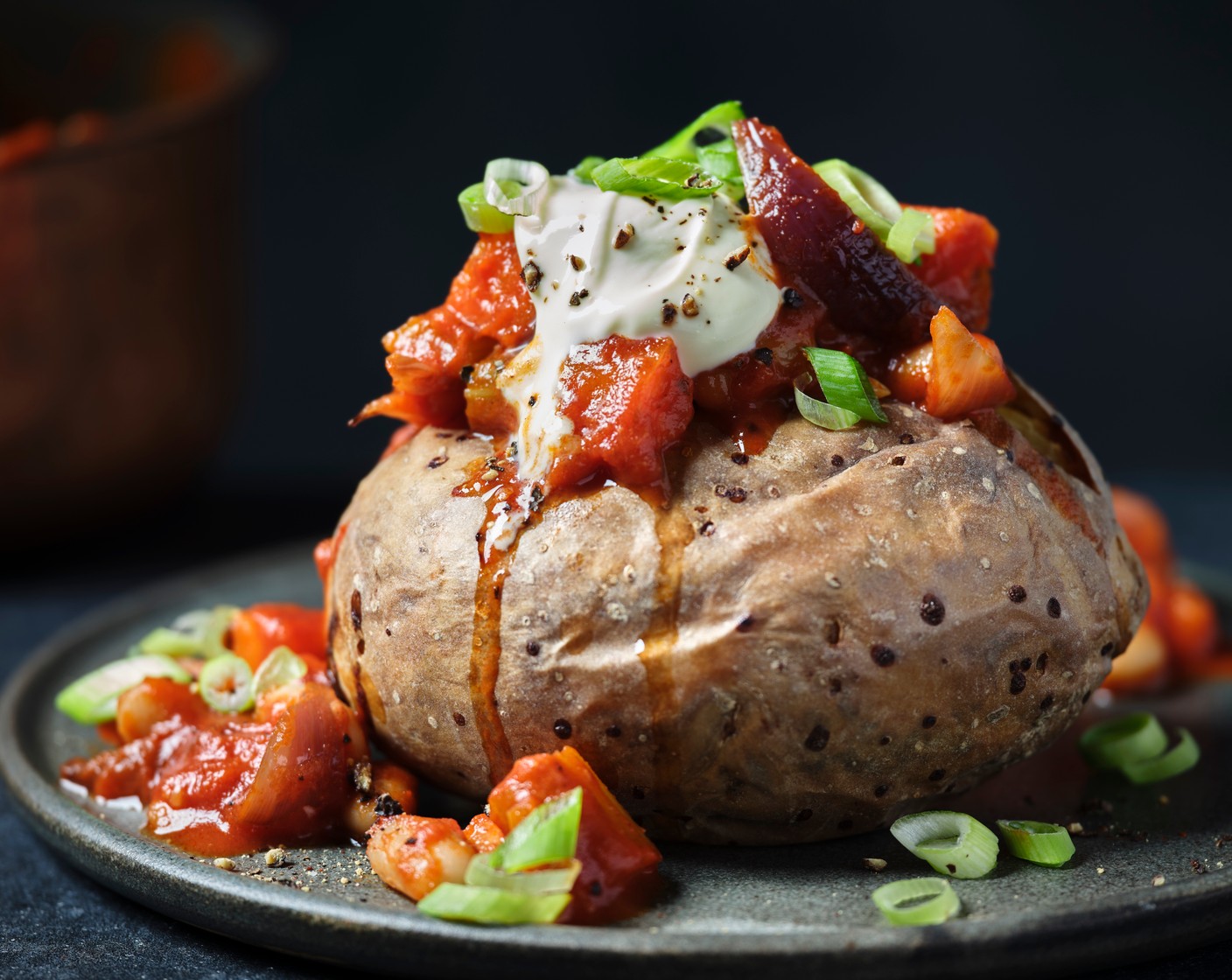step 8 Serve the beans with the jacket potatoes, soured cream (4 tbsp), spring onions (1 bunch) and coriander (1 bunch).