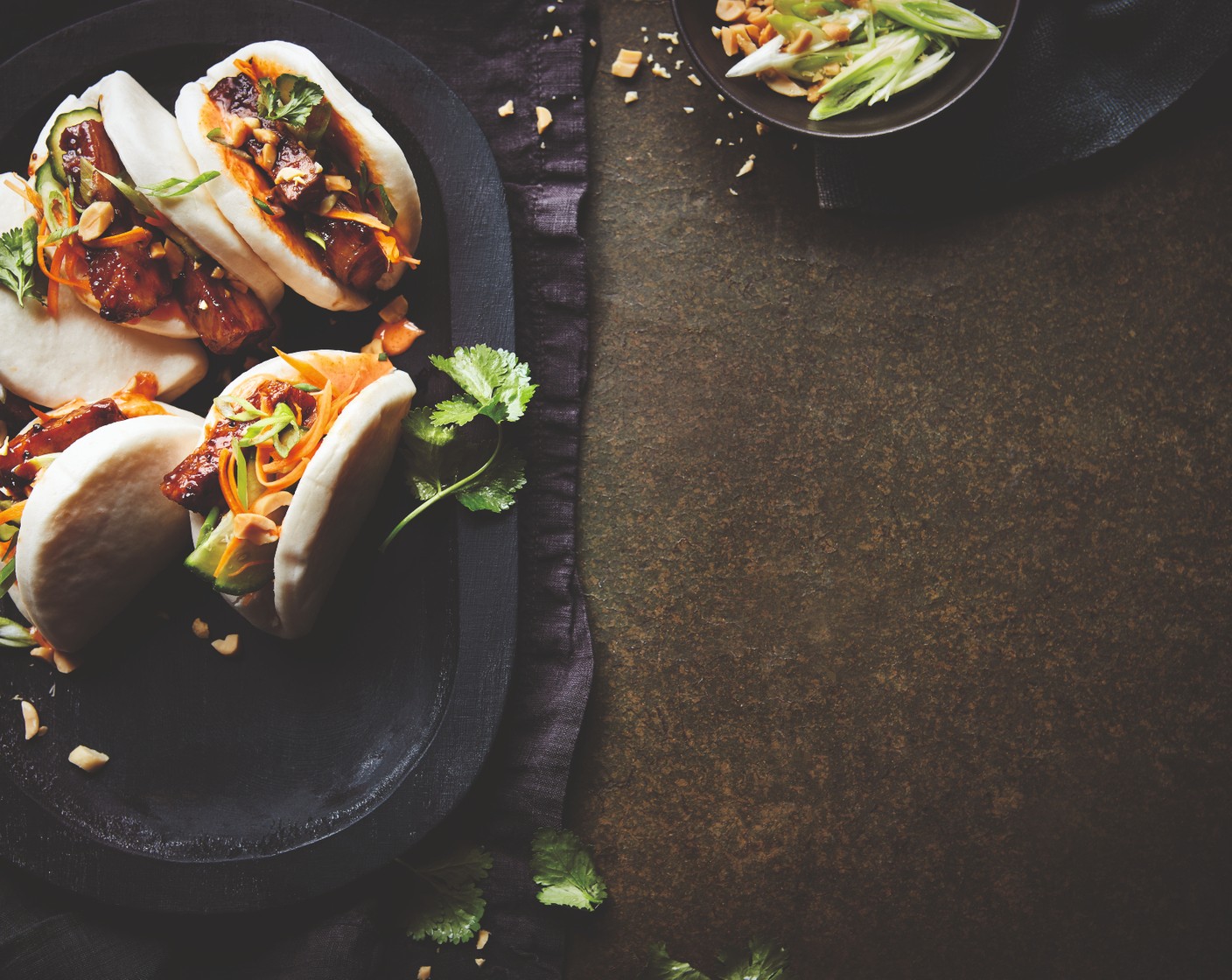 step 9 Top each bao bun with the chopped peanuts (1 handful), spring onions (2), coriander leaves (to taste) and some chilli (1), if you like it.