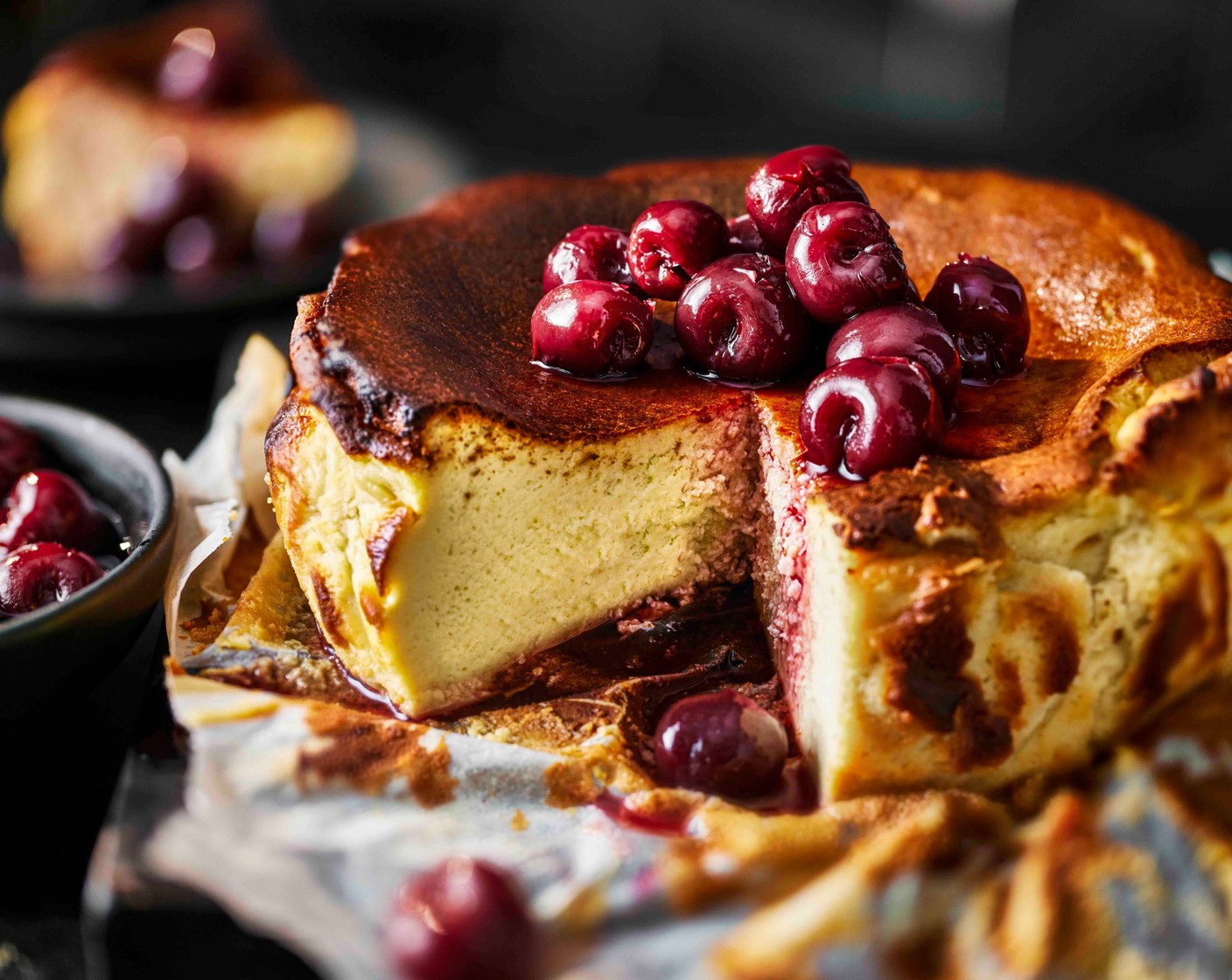 step 6 To serve, remove the cheesecake from the tin and peel away the baking paper. Slice and serve with the cherries in kirsch (as needed) spooned over the top.