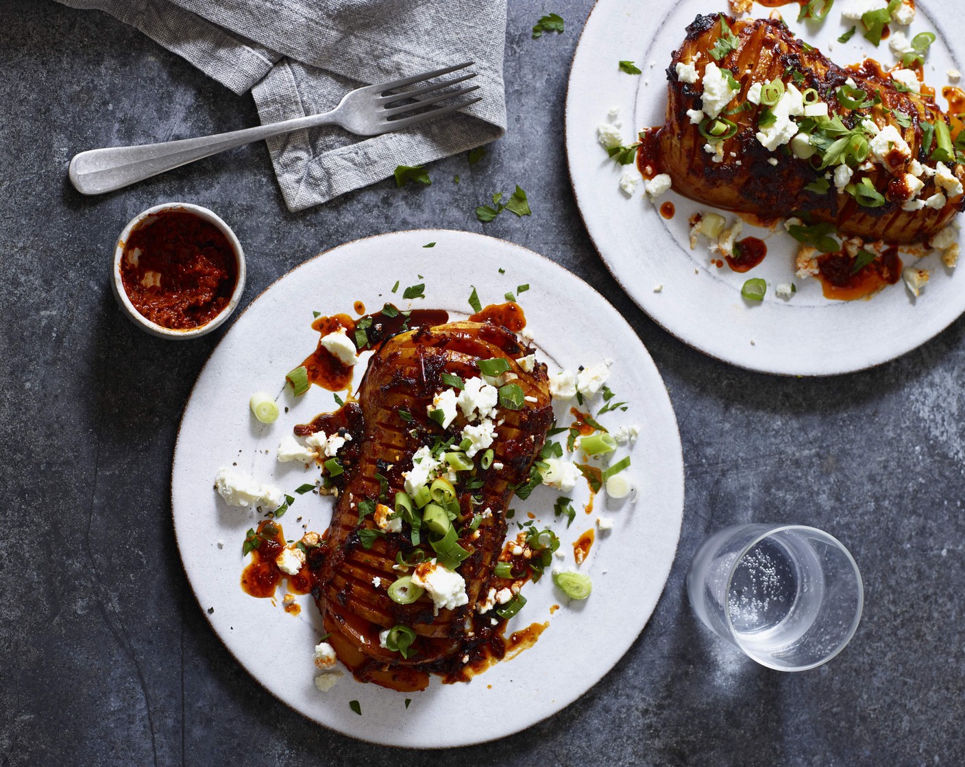 step 6 Remove from the oven, place on a serving dish and drizzle over any remaining harissa mixture. Serve with the crumbled feta (100 g) and spring onions (5).