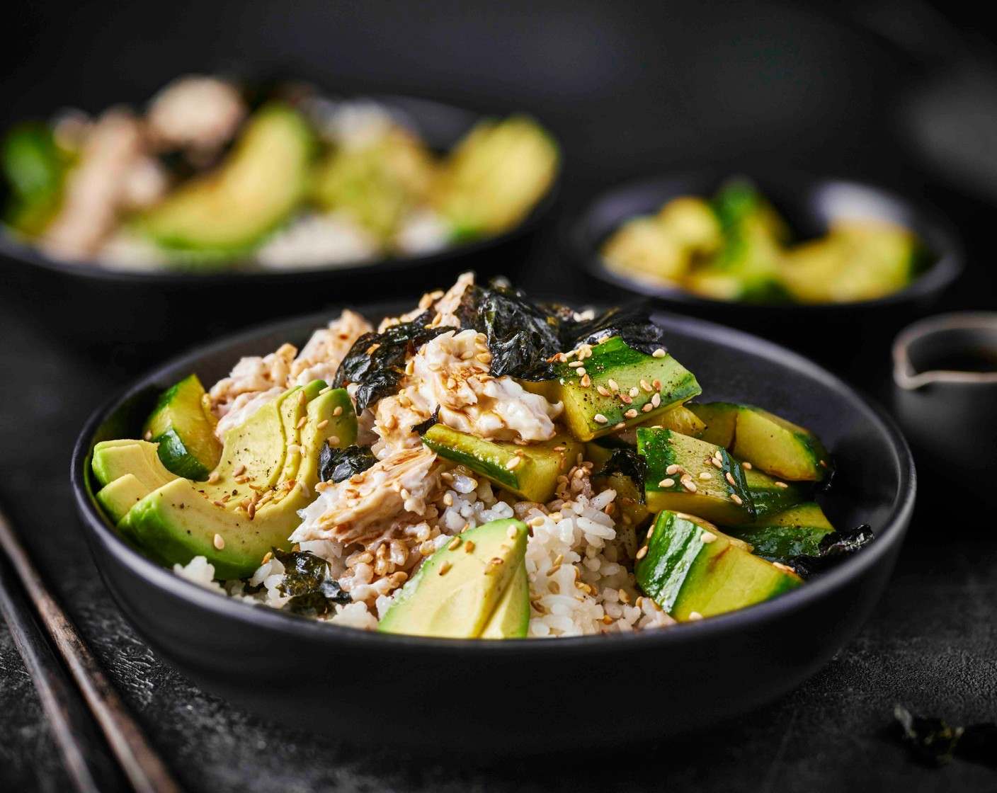 step 6 Divide the rice between the two bowls, then top with the smacked cucumber, sliced avocado and tuna. Spoon over any remaining dressing from the cucumber. Break over the nori sheets (2) into bite-sized pieces, and sprinkle with the toasted sesame seeds.