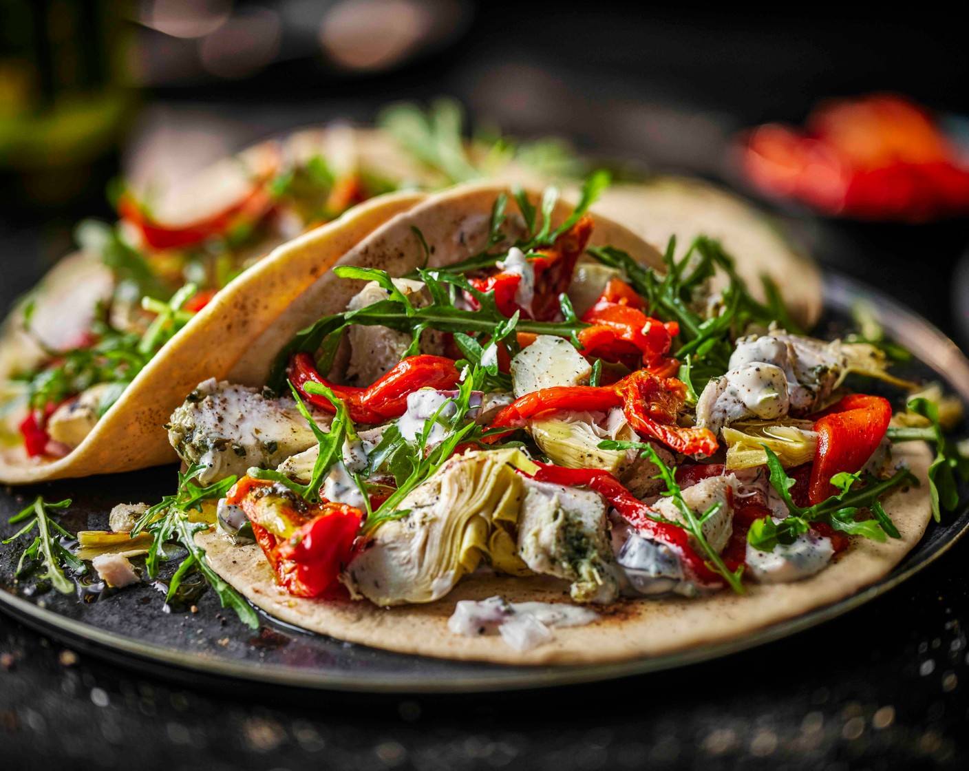 step 3 Roughly mix the chicken (1 pack), semi-dried tomatoes (50 g), red peppers (100 g) and artichokes (75 g). Spoon over the dip and top with a handful of rocket (50 g). Wrap up and dig in.