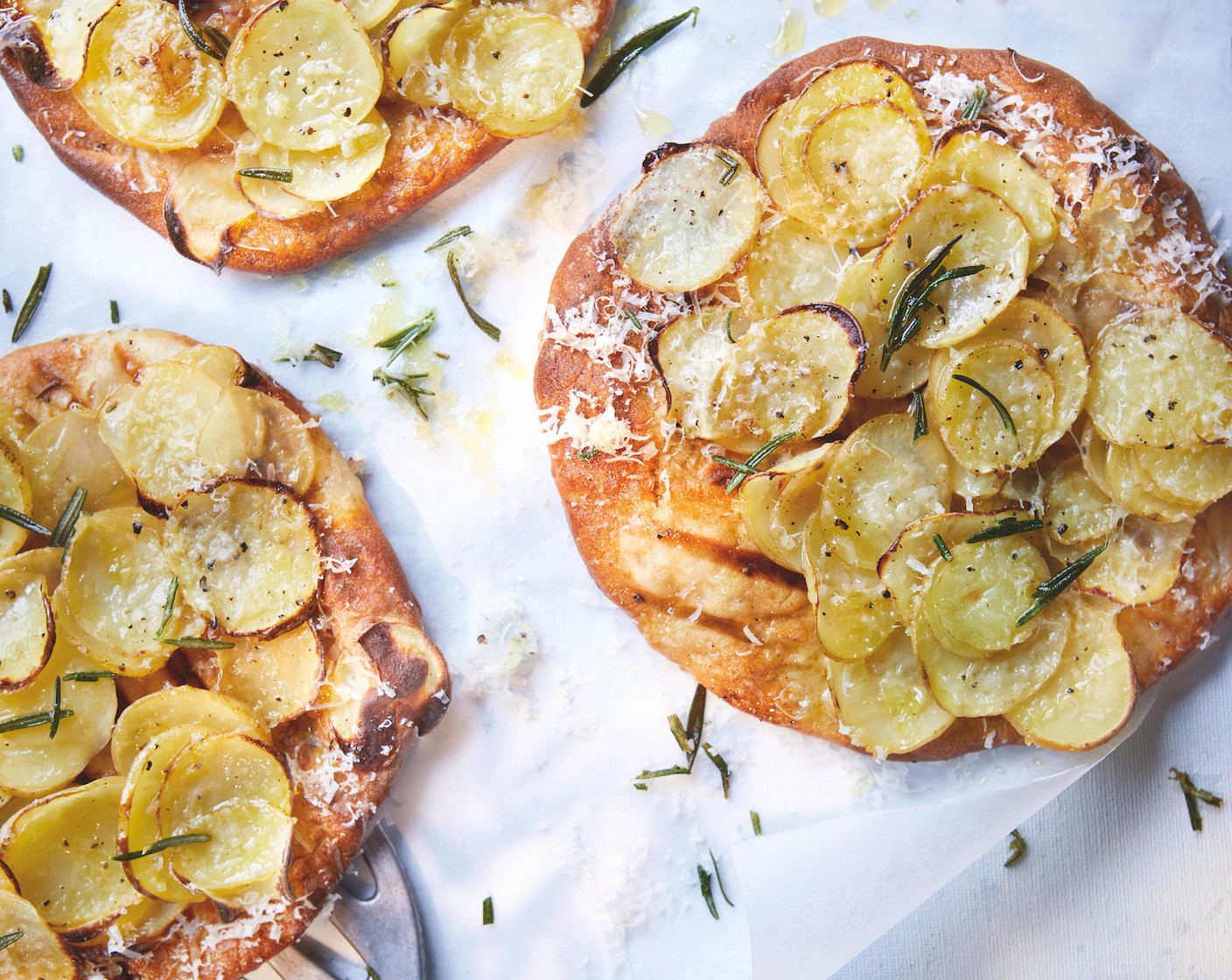step 7 Remove from the oven and add a scattering of parmesan (2 tbsp), some rosemary leaves (to taste) and a drizzle of truffle olive oil (to taste) to each flatbread, then place back into the oven. When the cheese has melted, they’re ready to serve.