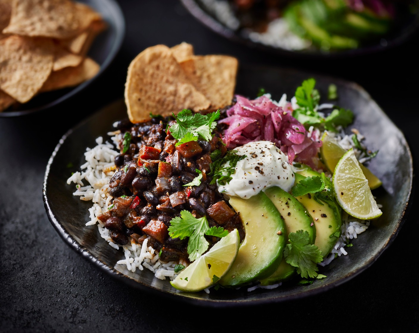 step 5 Spoon the rice into bowls and serve with the black beans, avocado, pickled red onions (2 tbsp), lime wedges (1), soured cream (to taste) and cantina tortillas (4 handfuls). Scatter with coriander (as needed) if you’d like.