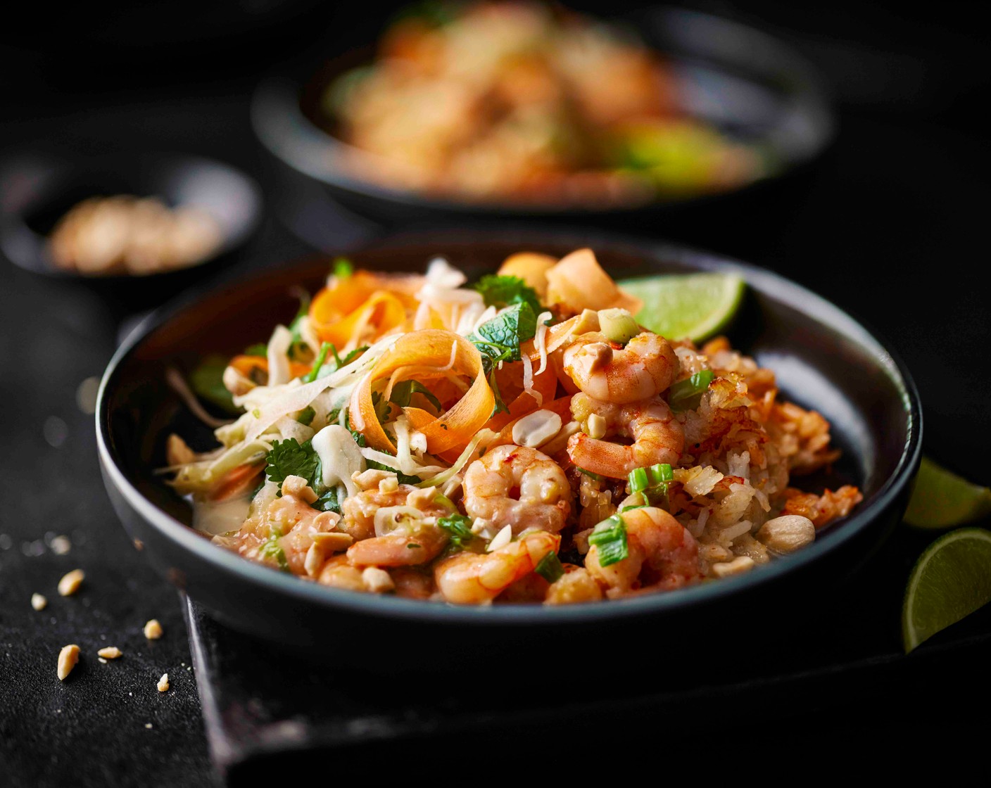 step 7 Add the crispy rice to four bowls, breaking up slightly. Top with the coconutty prawns, the salad and some chopped peanuts (75 g). Serve with the remaining lime (1), cut into wedges.