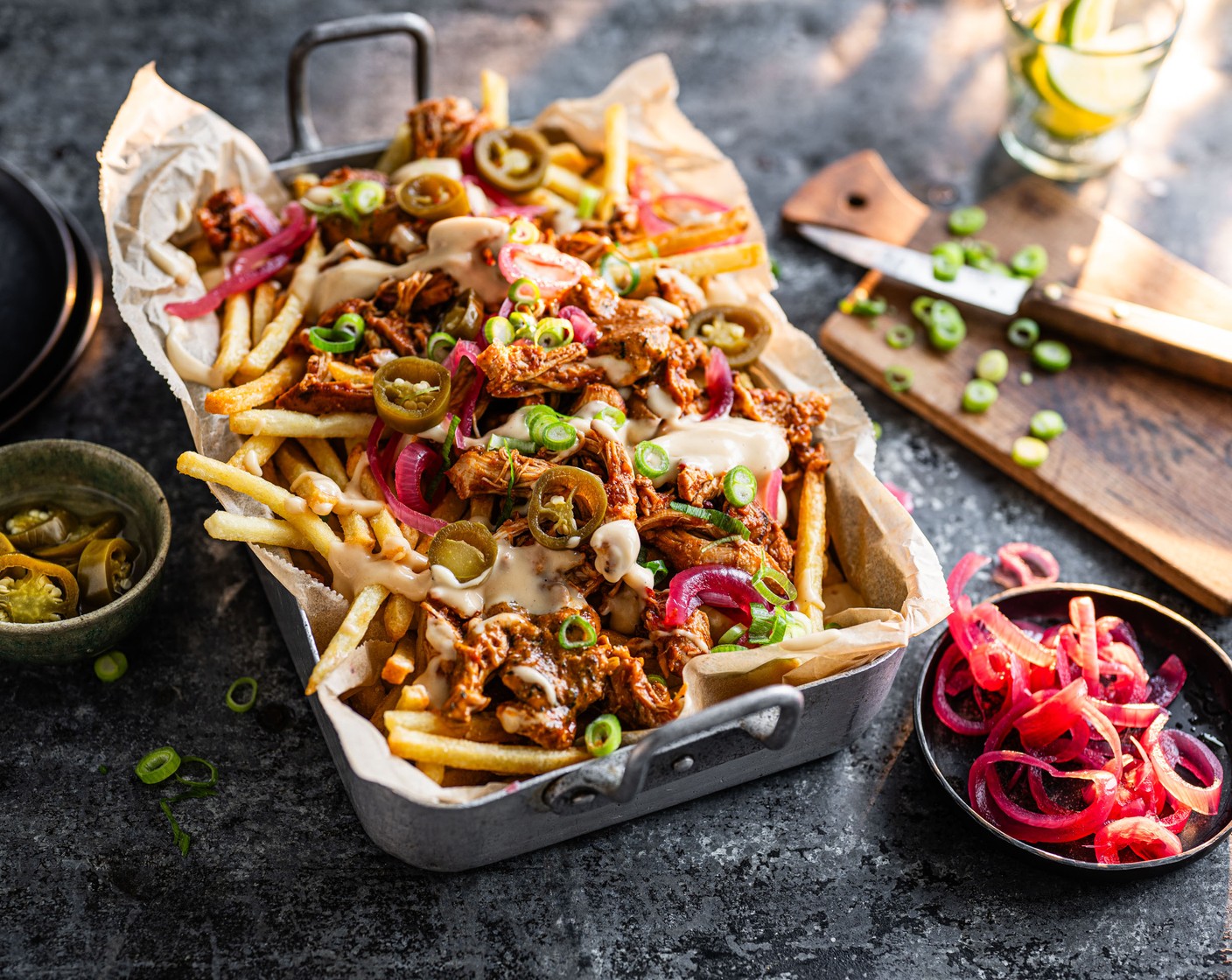 step 6 To assemble, pile your fries into bowls, top with the pulled chicken, paprika and chilli butter (1 tbsp), Cornish cruncher sauce (1 pack), jalapeño (1 handful), pickled red onions (2 tbsp) and spring onions (as needed). You can either serve the loaded fries individually or have one large serving bowl for everyone to help themselves to.