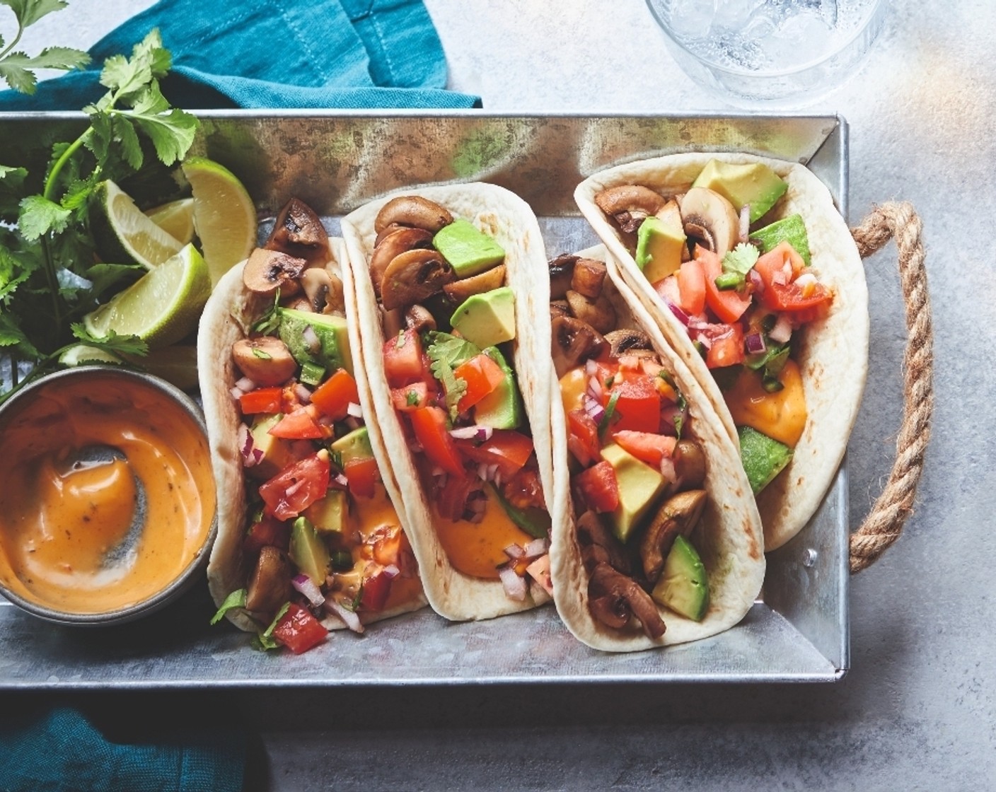 step 3 Warm the tortillas (8) under the grill until soft, then remove. Pile the avocado (1) and mushrooms on top of each taco, then layer on the pico de gallo and chipotle mayo (115 g). Add a squeeze of lime (1), then fold up to eat.