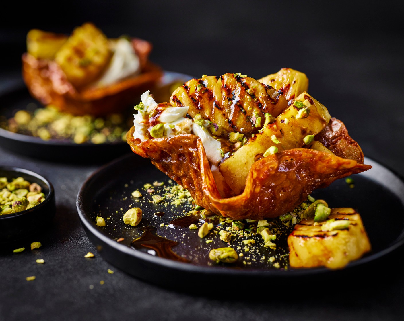 step 14 Put a small spoonful of the pistachio crumb in the centre of the plate. Sit a basket on top, quenelle a spoonful of lime mascarpone inside the basket, top with a few of the pineapple chunks. Garnish with a little more pistachio crumb. Repeat with the remaining two baskets and serve immediately.