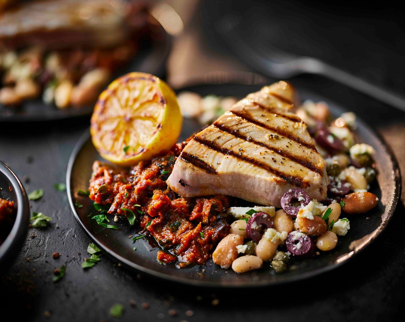step 3 Serve the tuna steaks with the caponata (1 pot), the Greek-style beans (1 pot) and the lemon halves.