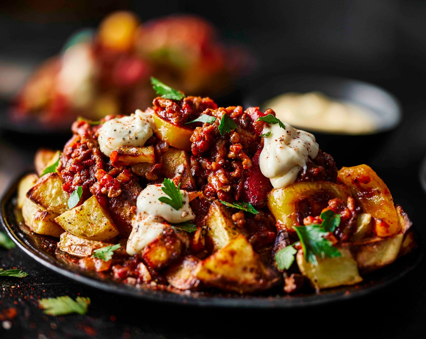 step 7 Divide the crispy potatoes between four bowls and spoon over the smoky beef sauce. Drizzle generously with the roasted garlic aioli (1 tub), scatter over the parsley (15 g) and finish with a pinch of smoked paprika to serve.