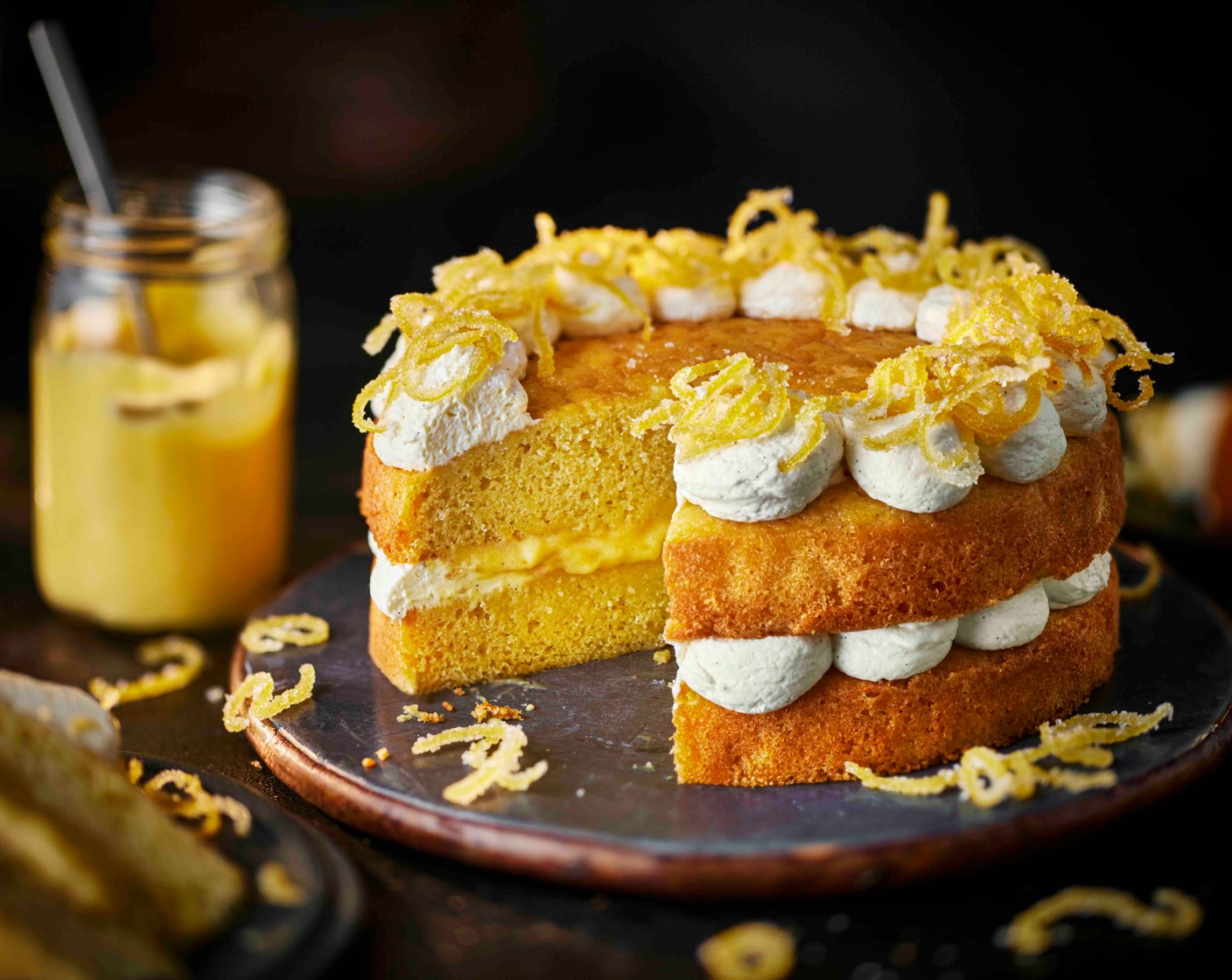 step 6 Place one sponge on a serving plate and pipe cream around the edge. Spoon the lemon curd into the centre and spread evenly. Top with the second sponge, pipe more cream around the edge and finish with the candied lemon peel.
