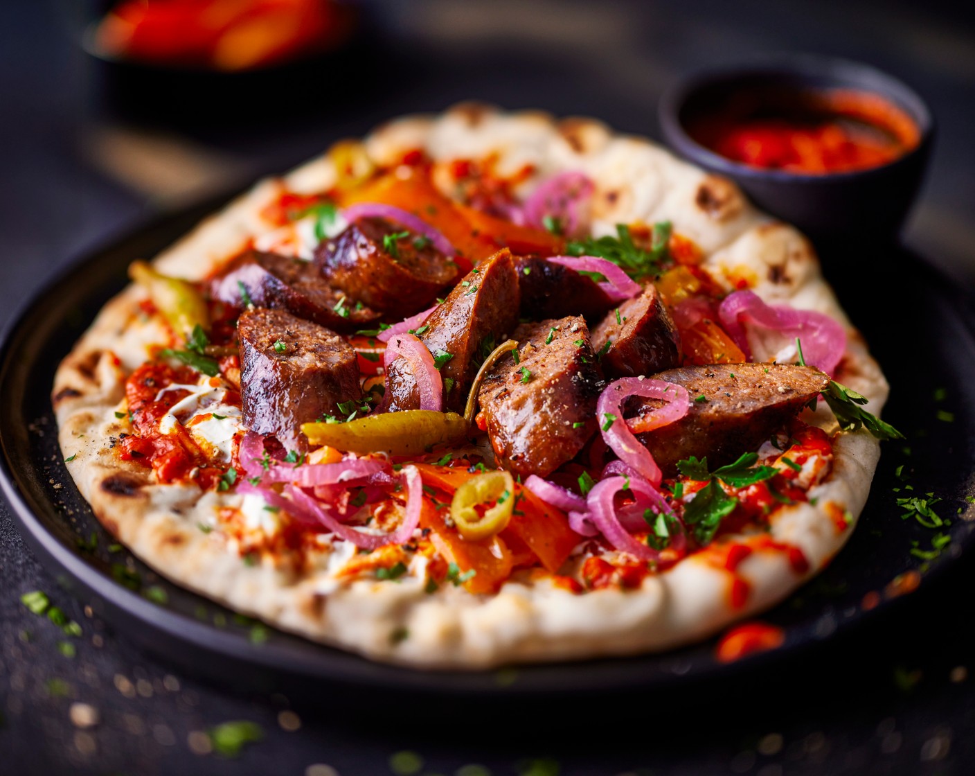 step 3 Top the flatbreads with the ajvar (1/2 tub) , sausages, sunburst peppers (2 tbsp), pickled chillies (2) and a drizzle of soured cream (2 tbsp). Top with some pickled red onions (1 tbsp) and a scattering of fresh parsley (15 g).