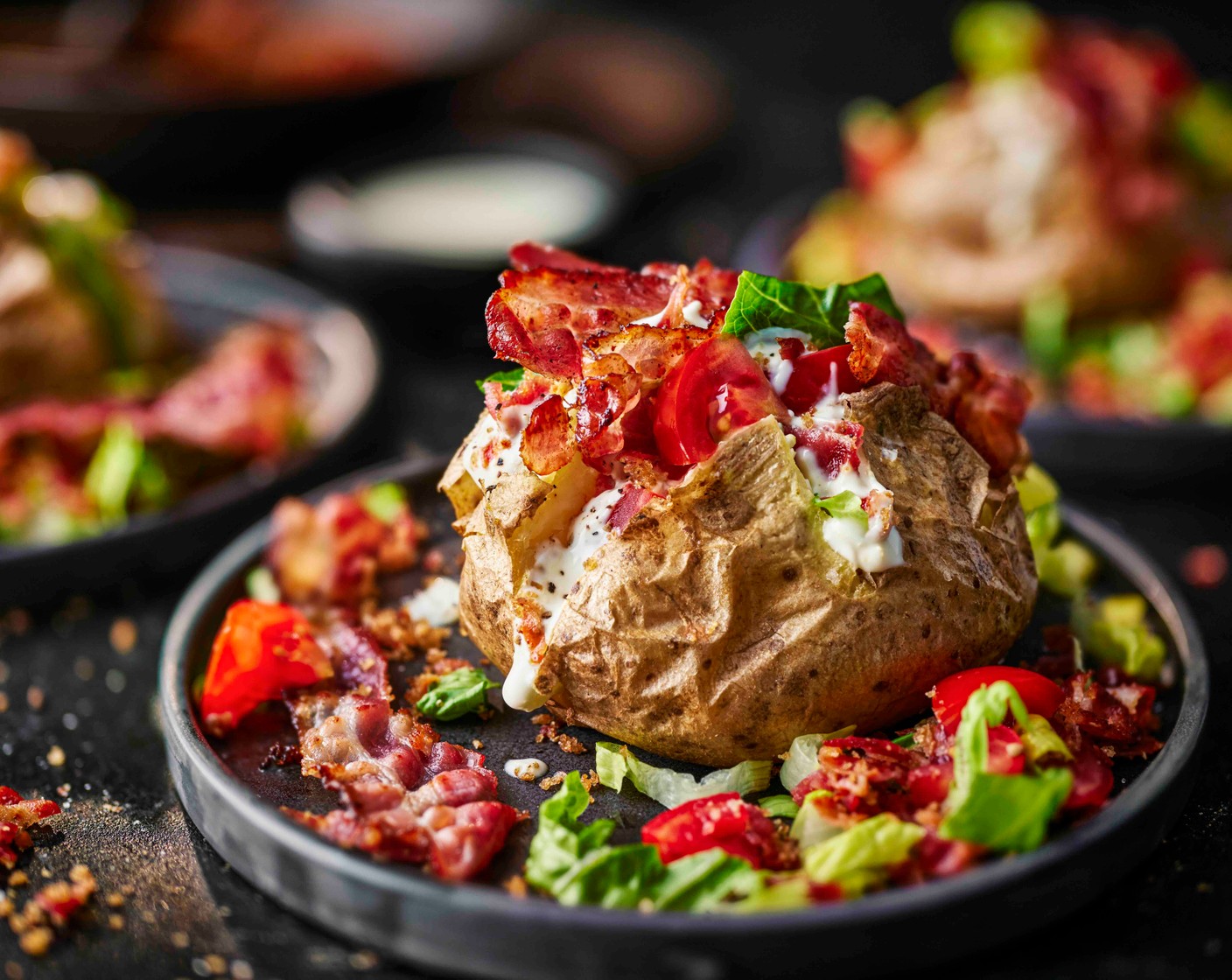 step 7 To assemble the potatoes, top with the lettuce and tomatoes, bacon, lemony soured cream mayo and crunchy bacon breadcrumbs.