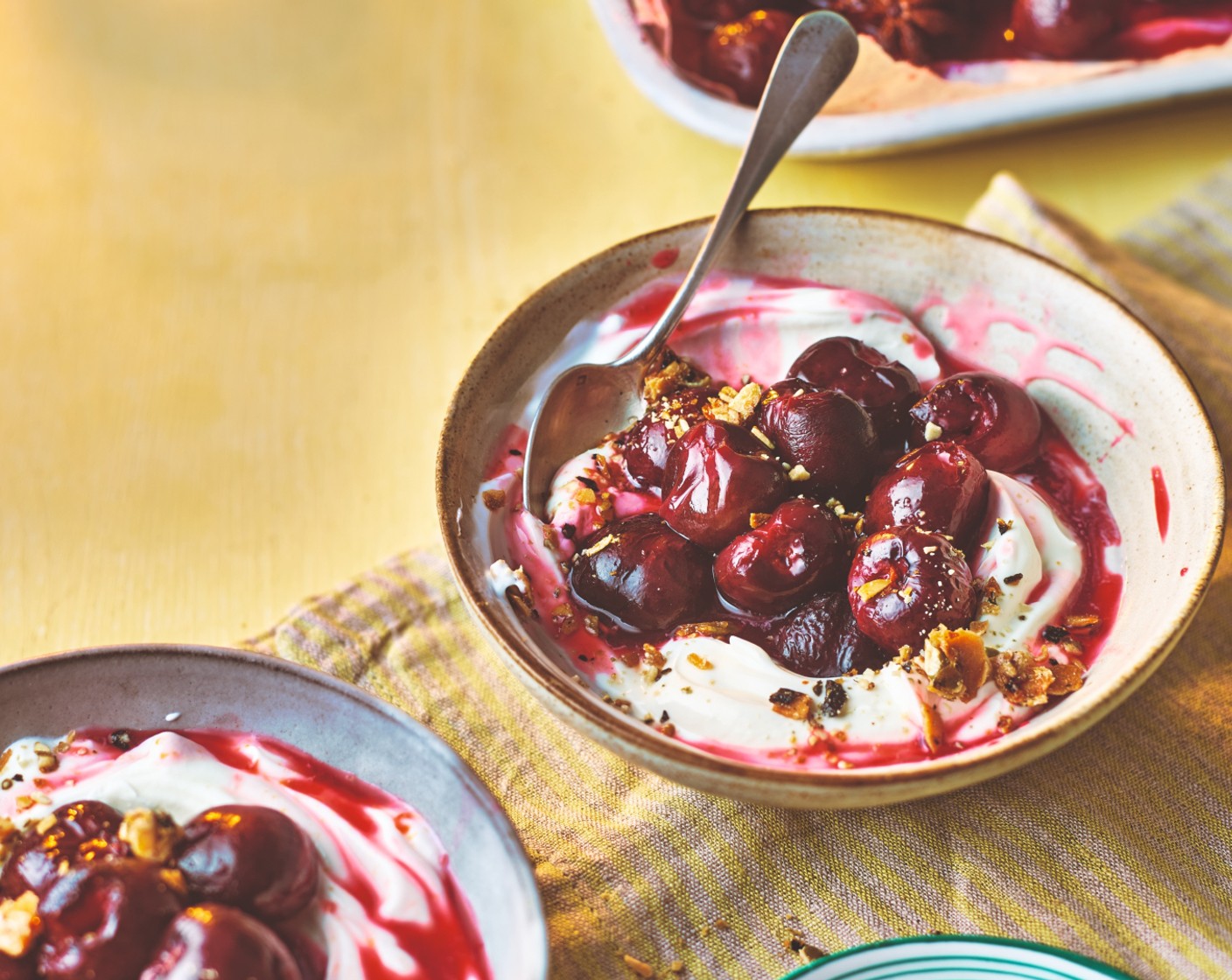 step 3 Divide the yogurt (400 g) between 4 bowls, then top with the cherries, a drizzle of their cooking syrup and the granola (30 g).