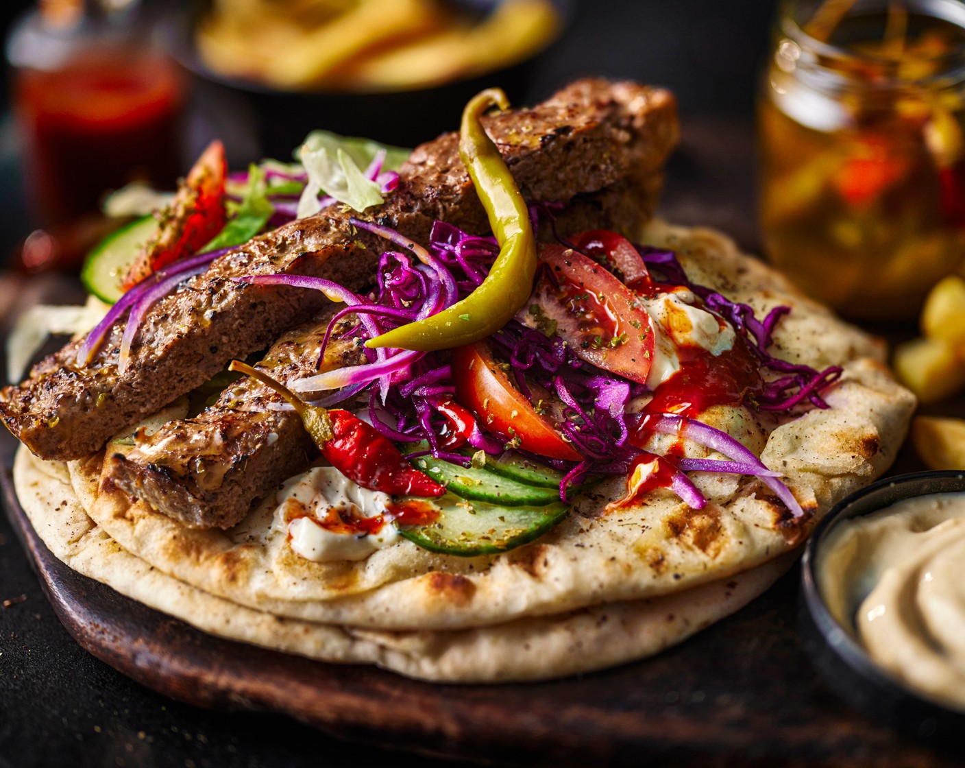 step 10 Cut the remaining lemon (1) into wedges. Pile the flatbreads with cabbage, lamb kebabs, red onions, salad, pickled chillies (to taste) and lemon wedges. Finish with garlic mayo (to taste) and naga chilli sauce (to taste), if using. Serve with the chips on the side.