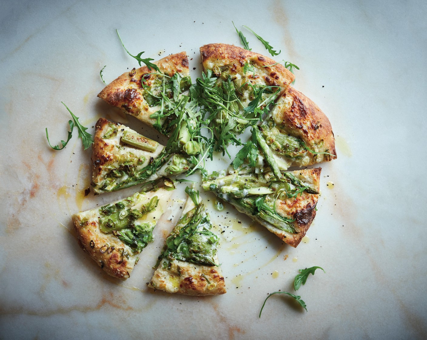 step 7 Cook in the oven for 10-12 minutes, or until well risen and nicely golden. Before serving, drizzle with more garlic and chilli flavoured olive oil if desired, and add another grating of parmesan and a handful of rocket (1 handful). Repeat with the remaining pizza dough.
