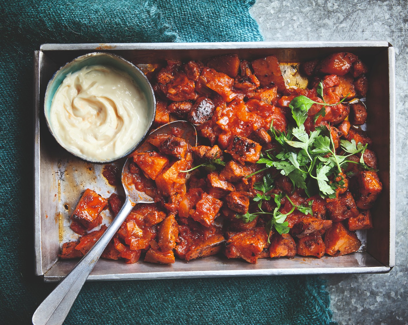 step 4 Remove the sweet potatoes from the oven and squeeze the garlic cloves from their skins. Stir the garlic into the mayo (4 tbsp), along with the lemon juice (1/2). Serve the potatoes topped with the tomato sauce, vegan chorizo, mayo and chopped parsley (1 handful).