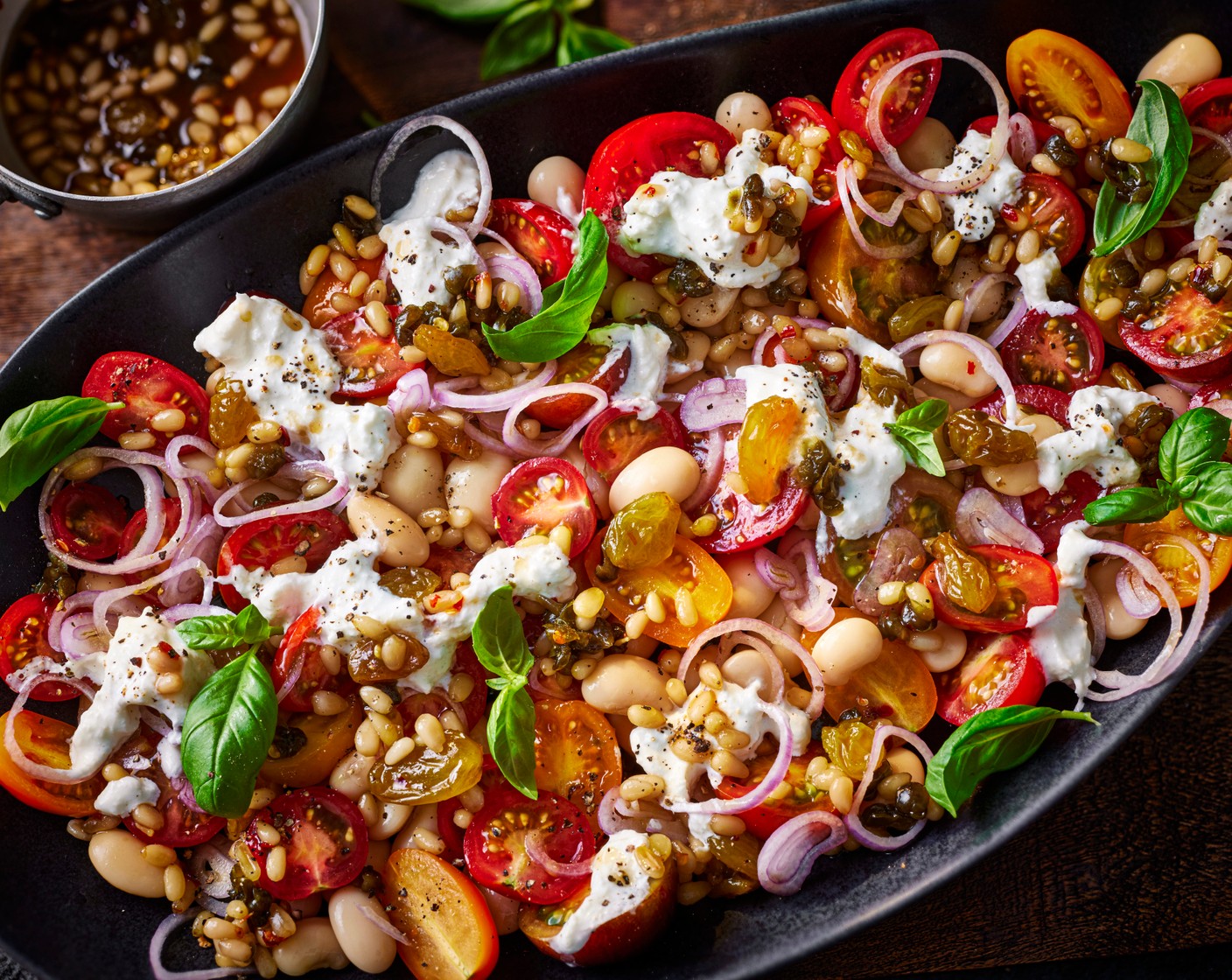 step 3 When you’re ready to serve, add the basil to the tomatoes. Serve on a platter, topped with the stracciatella (100 g). Dollop over the dressing to finish.