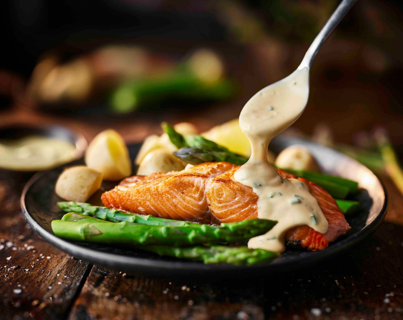 step 6 Stir the chives (1 tbsp) into the hollandaise. Serve the salmon with the asparagus and baby new potatoes alongside. Spoon the hollandaise over the salmon, add a wedge of lemon (1) and serve.