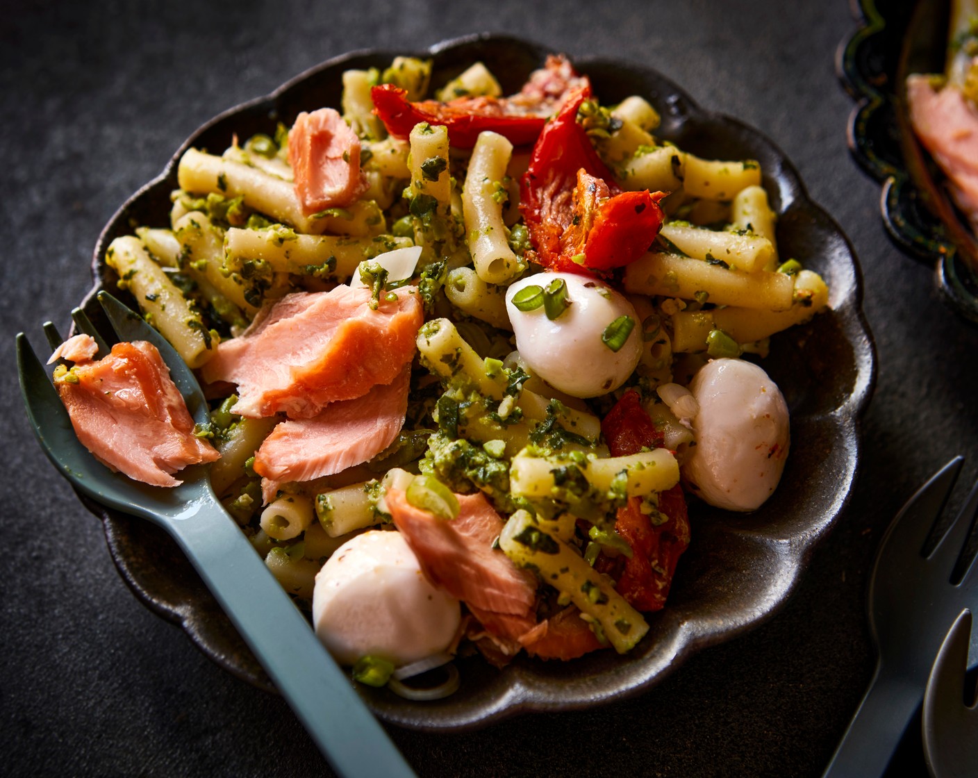 step 5 Serve the pasta with the smoked salmon (200 g), tomatoes and mozzarella (1 pack) and spring onions (1 bunch), letting everyone help themselves to their chosen toppings.