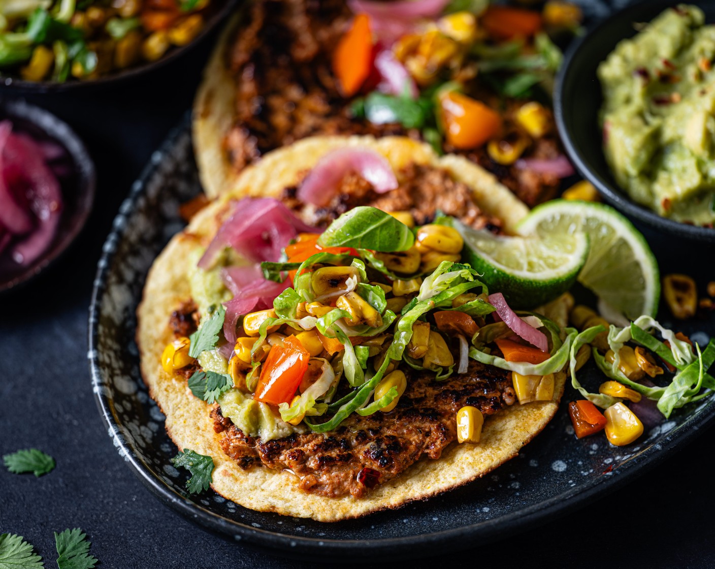 step 8 Serve the tacos with the sprout slaw, pickled red onions (2 tbsp), guacamole (1 tub), and remaining fresh coriander (10 g). Serve with the remaining lime (1), cut into wedges.