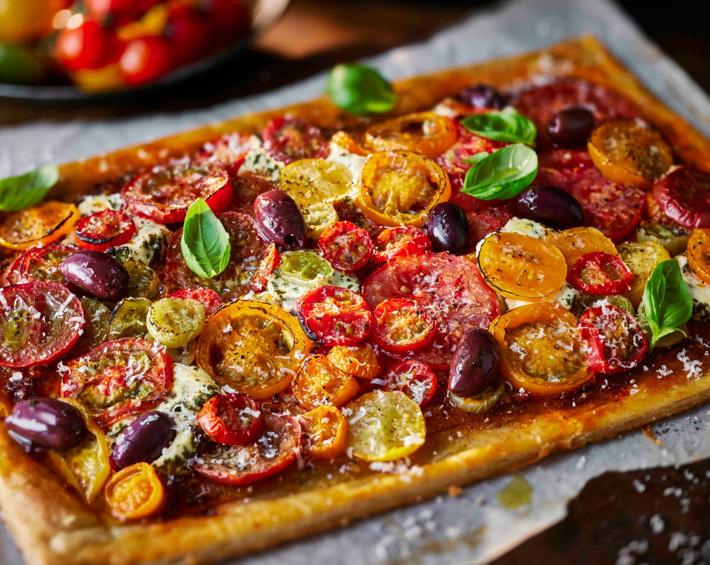 step 8 Remove from the oven and leave to cool slightly. Scatter over the olives (50 g), slice into 6 pieces, then finish with the basil (10 g) and a drizzle of olive oil. Serve warm or at room temperature, with a green salad if you like.