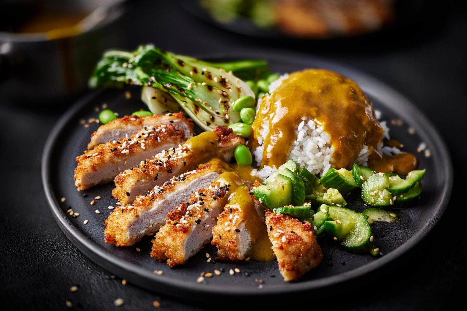 Chicken katsu curry with sushi rice, smashed cucumber and pak choi
