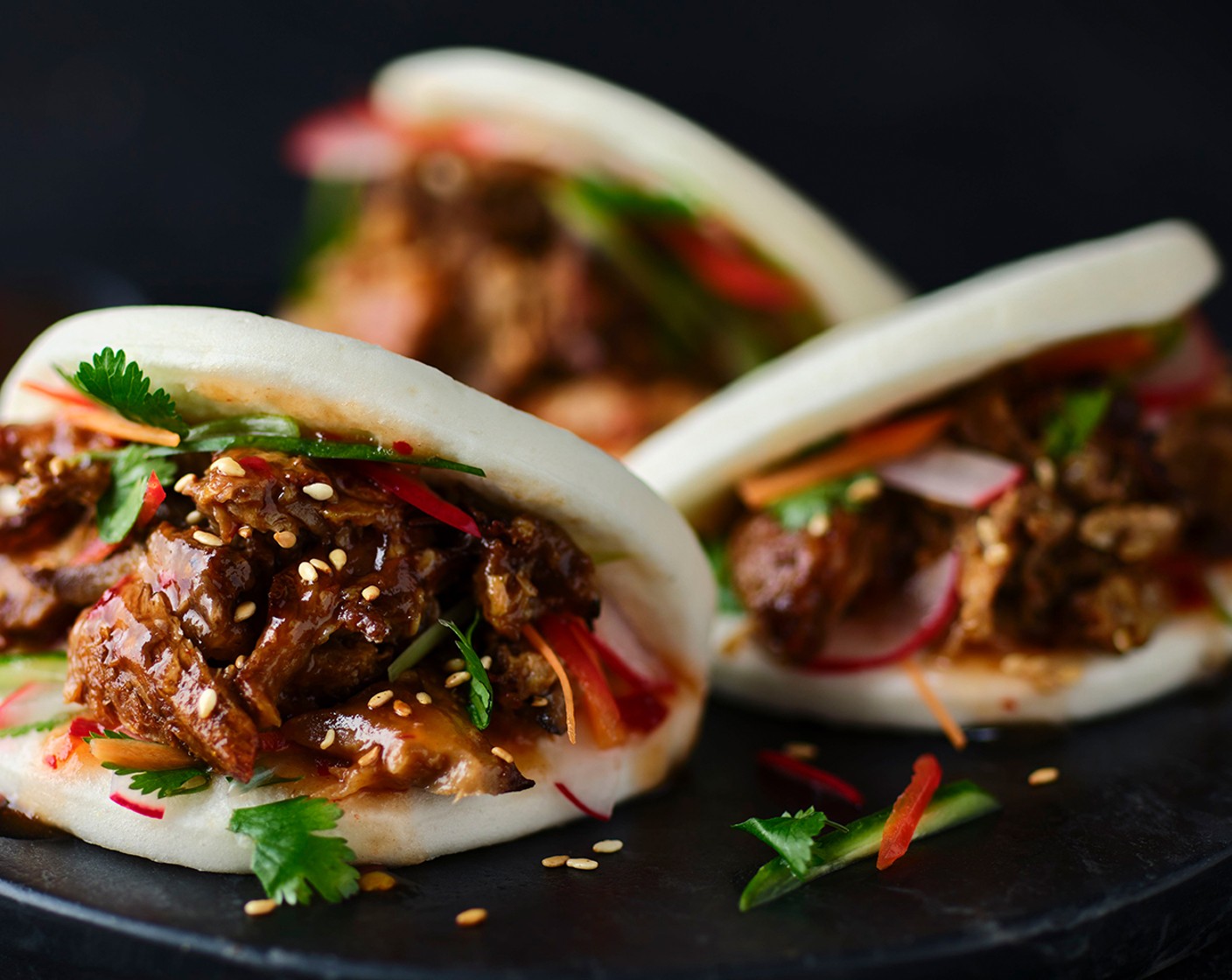 step 7 Carefully pull apart the buns and fill them with a layer of sriracha mayo, and top with the pulled mushroom mix. Load in the quick-pickled veg and top with the sesame seeds (2 tsp) and coriander (as needed).