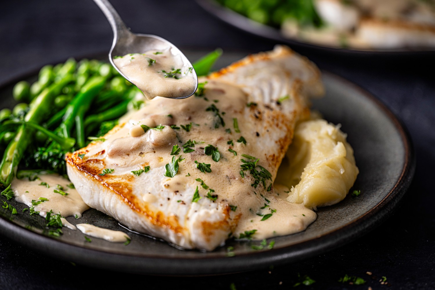 Pan-seared halibut fillets in a creamy lemon sauce with mashed potatoes