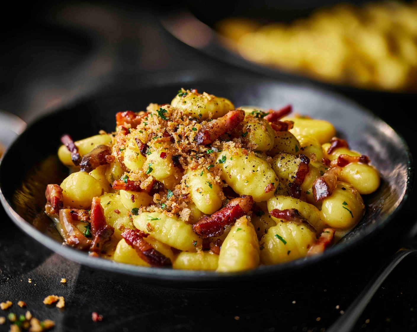 step 7 Add the gnocchi to a serving dish and top with the suino nero, parsley breadcrumbs and a good crack of black pepper.