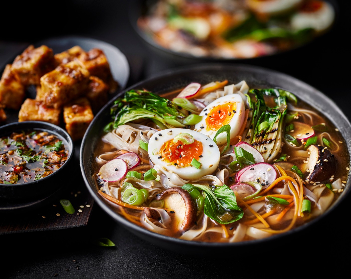 step 9 Gently pour the broth into the noodle bowls and top with white sesame seeds (1 tsp), black sesame seeds (1 tsp) and a drizzling of sesame oil (1 tbsp). Serve the sweet chilli sauce and crispy tofu on the side.