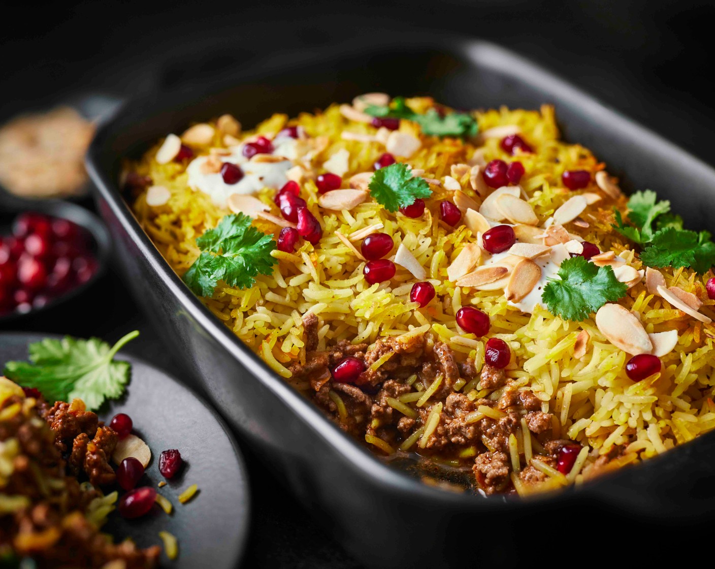 step 6 Scatter the biryani with the toasted almonds and pomegranate seeds (3 tbsp). Finish with coriander (as needed), if you like, and a dollop of yogurt (as needed).
