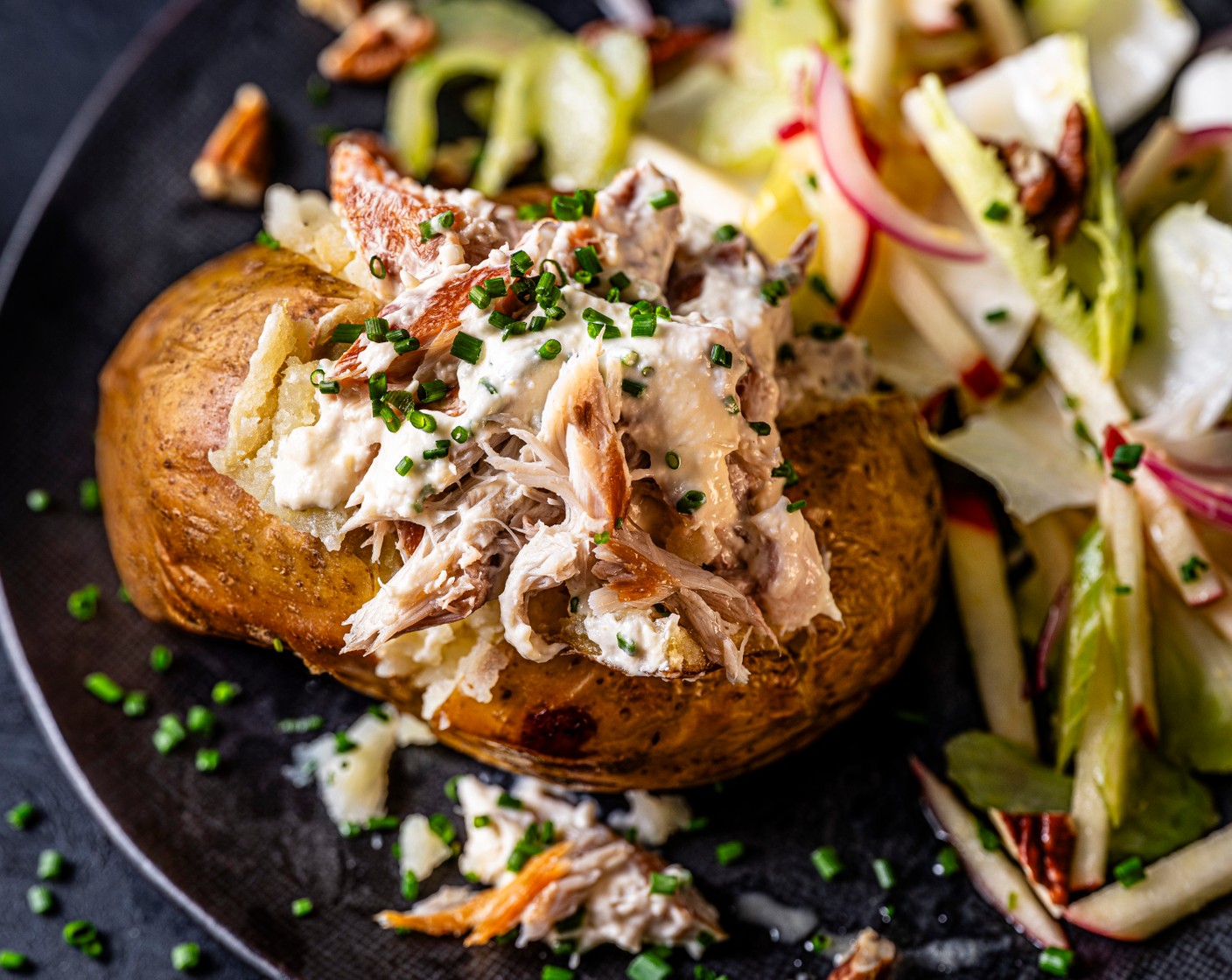 step 4 When the potatoes are ready, scatter the pecans (25 g) over the slaw. Serve the potatoes with the smoked mackerel mix and the celery slaw, with a scattering of chives on top.