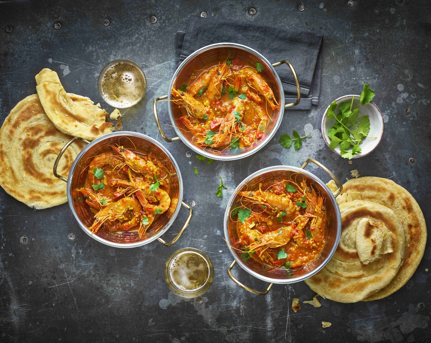 step 7 Divide the prawns between 4 serving bowls, and serve each with a warm paratha.