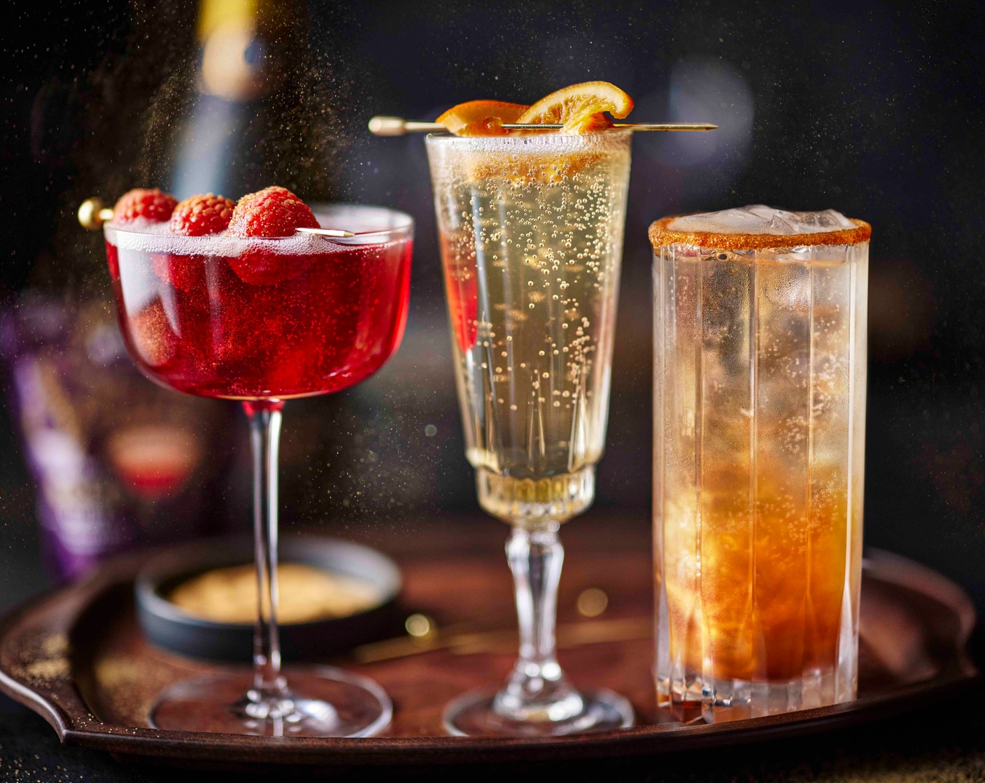 step 3 To make the sparkling Kir Royal, Add the creme de cassis (20 ml) to a coupé glass. Top up with the Prosecco (100 ml). Add the Magic and Sparkle dust (1 tsp) to a small plate, and gently roll the raspberry (3) in it before threading onto a cocktail stick. Use to garnish the drink.