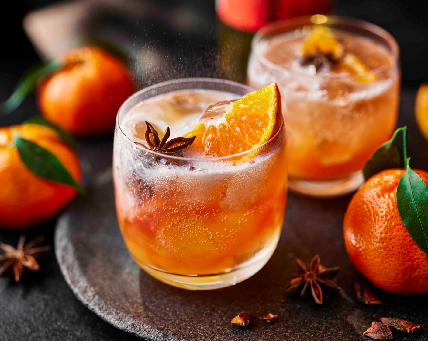 step 1 Fill a large wine glass with ice (as needed). Pour in the cranberry juice (50 ml), apple juice (50 ml) and clementine juice (1/2). Top with the ginger kombucha (100 ml) and gently stir. Garnish with a clementine wedge (1 wedge) and star anise (as needed) to serve.
