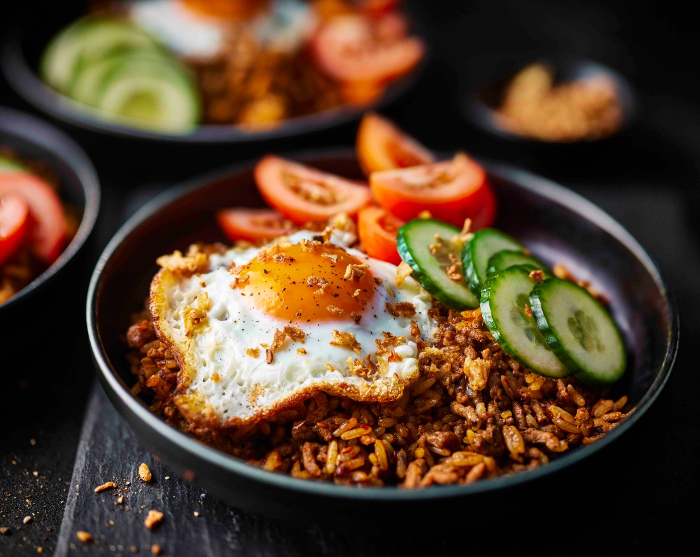 step 5 Serve the beef nasi goreng in bowls, topped with the fried eggs, sliced cucumber (1) and tomatoes (4). Sprinkle over some crispy onions (2 tbsp) (optional) for extra crunch.