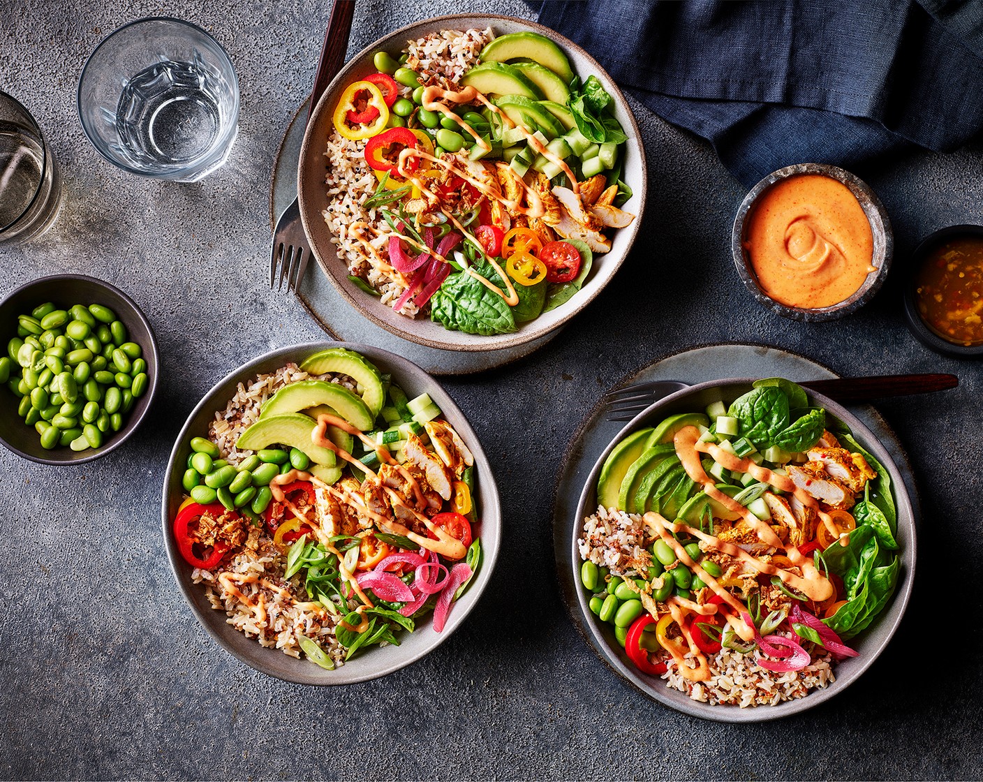 step 4 Arrange your sliced red pepper (1) and yellow pepper (1), diced cucumber (40 g), avocado (1/2), sliced tomatoes (80 g), edamame beans (40 g) and your chicken pieces (90 g) however you like, then top with the crispy onions (2 tsp), red onions (20 g) and sliced spring onion (1). Finish with a drizzle of mayo (spicy or non-spicy!).